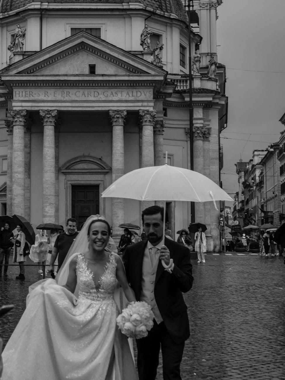 newlywed couple walking in front of santa maria in montesanto church in rome in italy